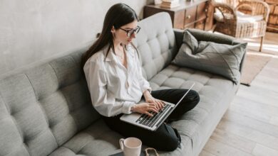 Hand typing on laptop with blank screen, symbolizing a digital CV.