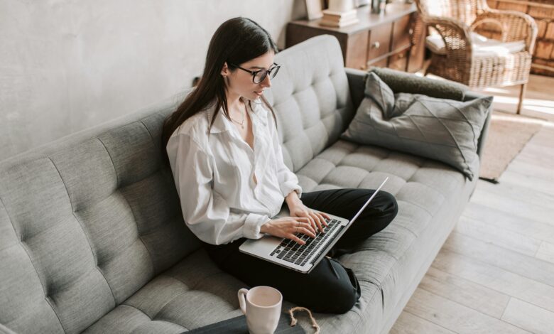 Hand typing on laptop with blank screen, symbolizing a digital CV.