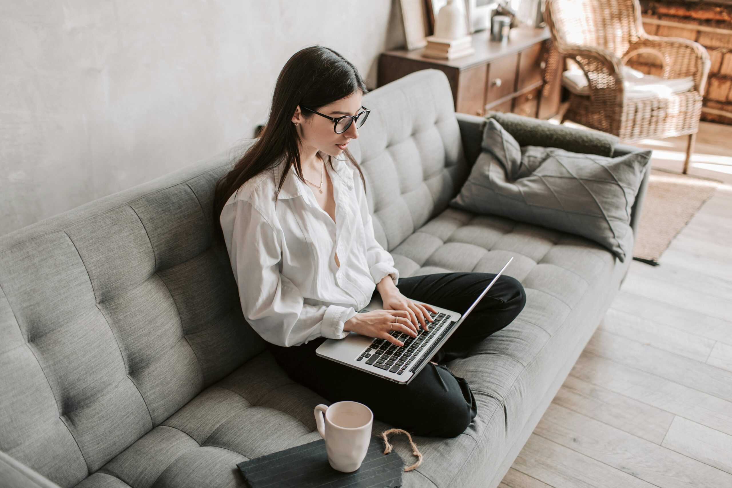 Hand typing on laptop with blank screen, symbolizing a digital CV.