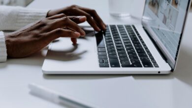Hands typing on a sleek laptop keyboard; modern technology in use.