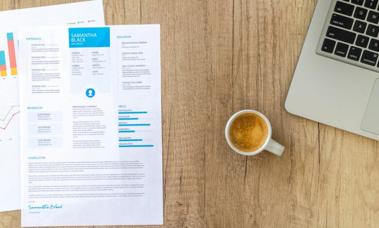Desk with resume, coffee, and laptop on wood. Perfect for business concepts.
