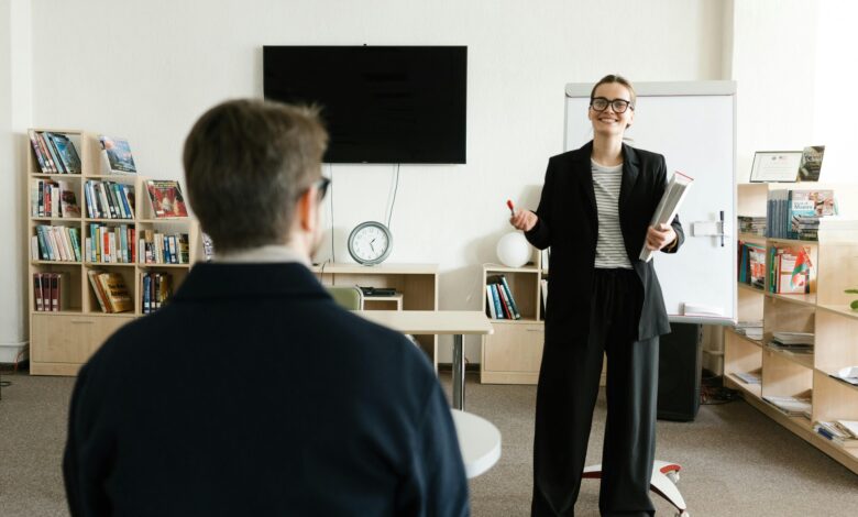 Businesswoman giving presentation in modern office with bookshelves and clock.