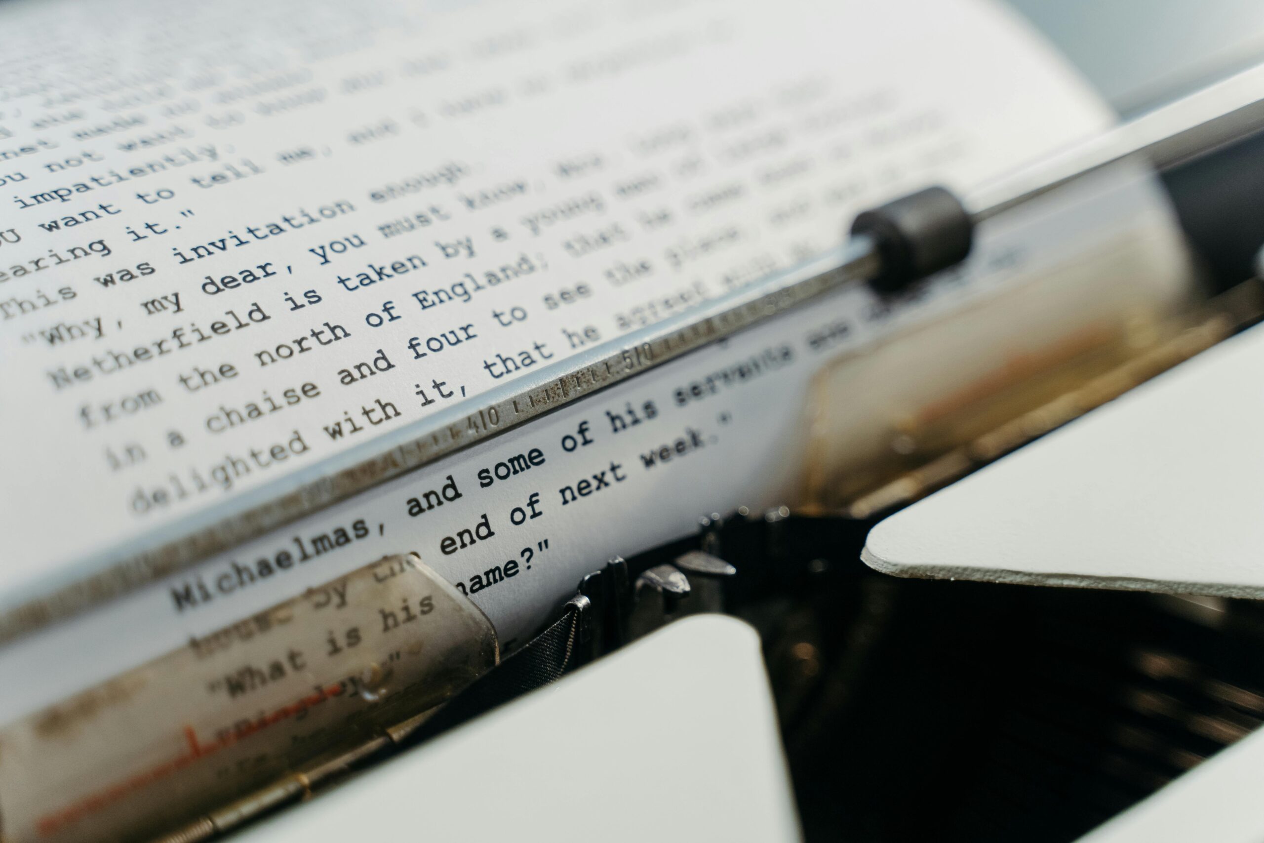 A vintage typewriter actively typing manuscript pages, evoking a sense of timeless creation.